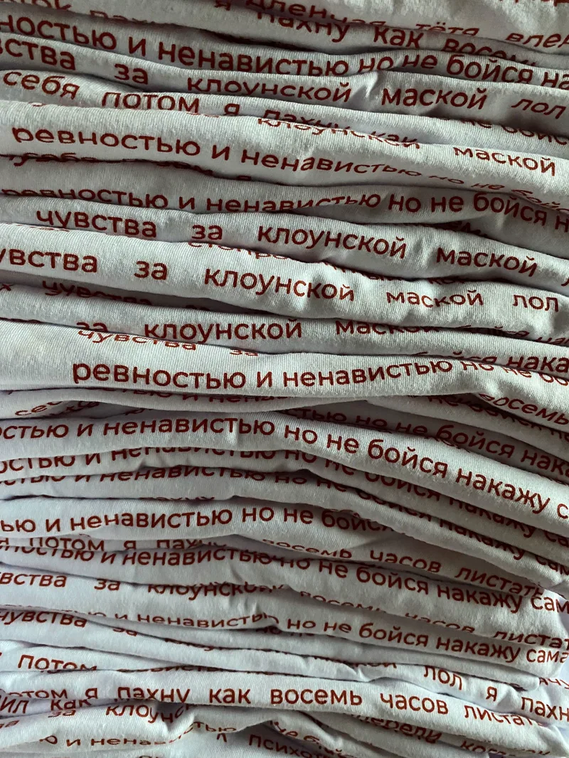 Стопка готовых белых футболок с текстом
